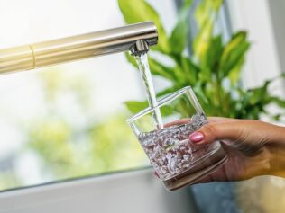 Woman,Hand,Holds,A,Glass,To,Filing,It,With,Water